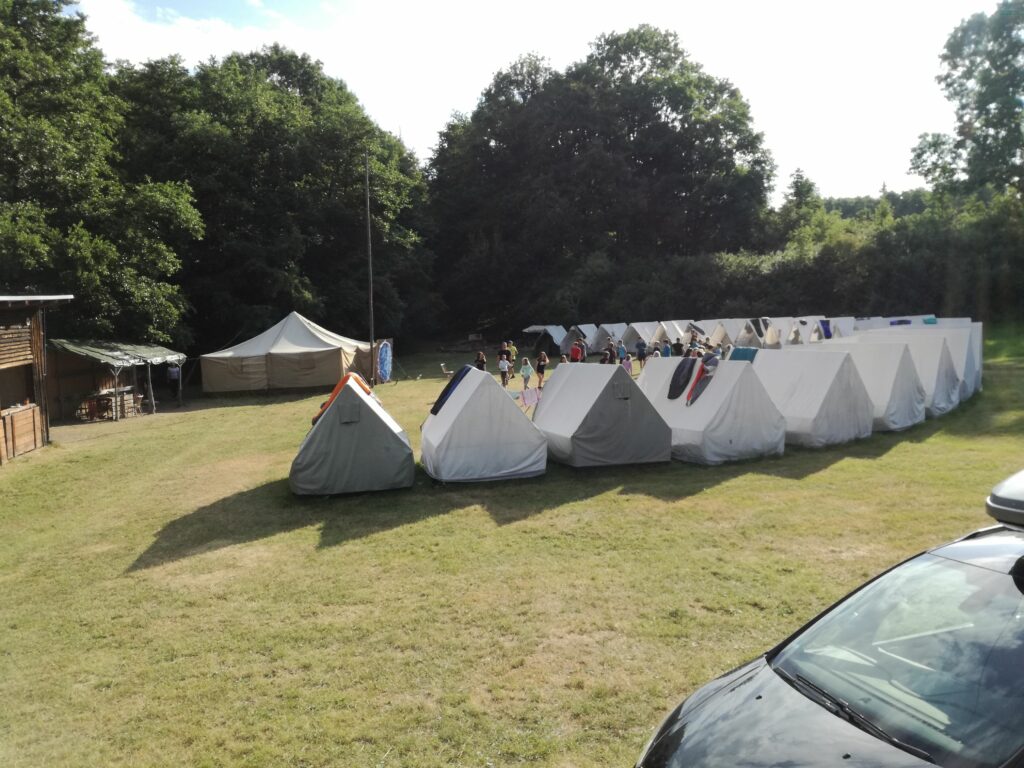 Pohled na celé tábořiště. Vojenský stan v pozadí obsahuje kompletně zapojenou konzoli, vše čeká na zahájení první hry.